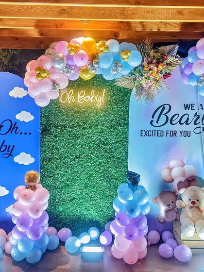 A close-up of the "Oh Baby" neon sign and grass wall.