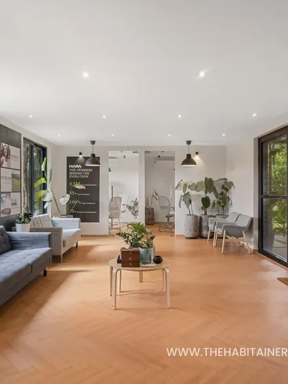 A duplicate of 73, highlighting the spacious and bright interior of the HARA office. The light-colored walls and wood flooring contrast with the dark exterior for a modern look.