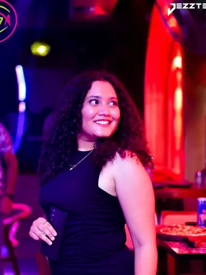 A smiling guest enjoying the ambiance of the club. It's not just about the music, but the entire experience.