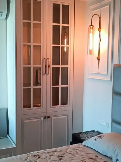 A classic white wardrobe with glass-paneled doors, perfect for a French or Victorian-style bedroom. The design is timeless and adds a touch of vintage charm.