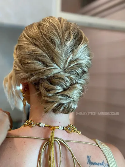 A close-up view of the textured updo on blonde hair, showing the detailed twists and secure finish.