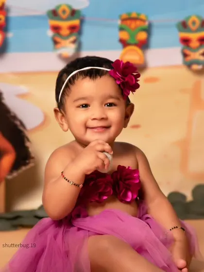 A close-up shot capturing the sweet and curious expression of a one-year-old during her Moana-themed photoshoot.