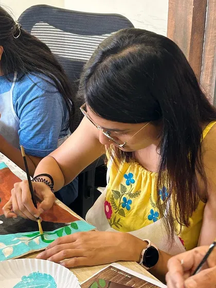 A participant adding the finishing touches to her tote bag. The vibrant colors and bold design are coming together beautifully.