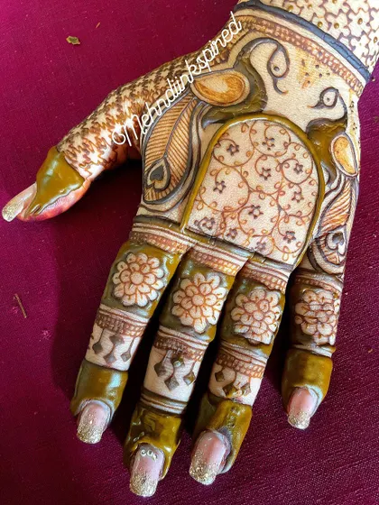 A custom design with a focus on peacock motifs. The fresh henna paste shows the precision of our line work, from the delicate feathers to the floral patterns on the fingers.