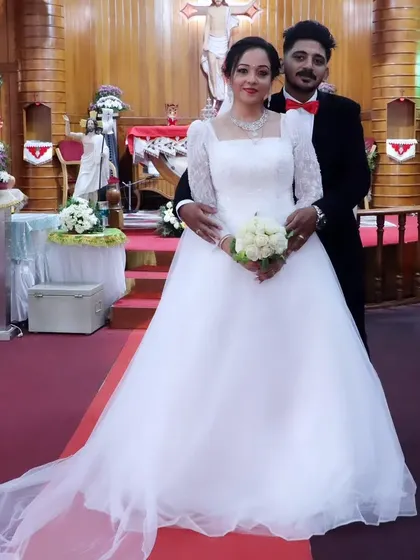 The happy couple. It's an honor to see my creation as part of such a beautiful union. The gown's classic silhouette and long train are perfect for a church wedding.