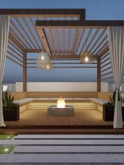 A beautiful wooden pergola with a central fire pit and built-in bench seating. The sheer curtains add a touch of softness and can be drawn for privacy.