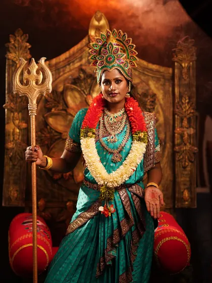 A powerful portrait in our Devi costume, featuring a colorful crown, flower garland, and trident, creating a truly divine image.