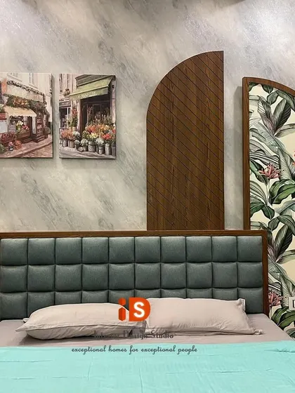A detailed shot of the headboard area in the guest bedroom, showcasing the combination of textures, from the tufted headboard to the wallpaper and wood panels.