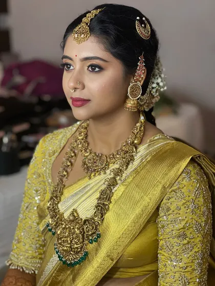 A side profile shot that highlights the intricate hair accessories and the beautiful contour of her makeup.