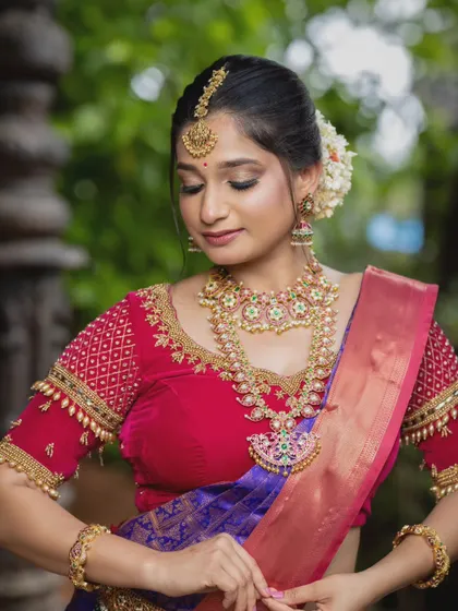 This close-up shows a beautiful kempu stone necklace set against a vibrant red and purple saree, highlighting how the jewellery can complement rich colours.