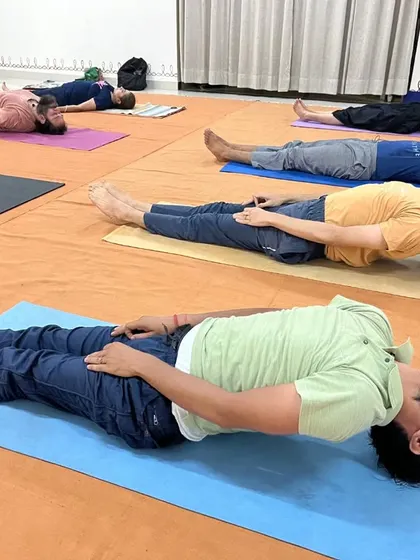 A group of men in Matsyasana, the fish pose, which opens the chest and throat chakras.