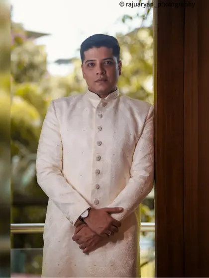 A classic, formal portrait of the groom. The indoor lighting and serious expression give this shot a timeless and sophisticated feel, perfect for a wedding album.