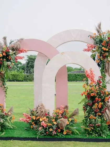 For the "Fireworks" themed wedding fraternity meetup, we created this stunning photo backdrop with interlocking arches and floral arrangements that mimicked bursts of color in the sky.