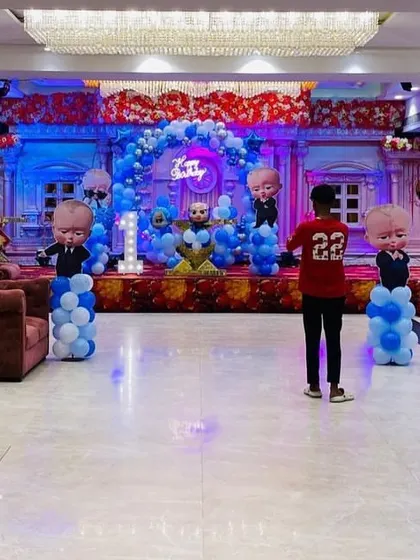 A wide shot of the 'Boss Baby' themed party hall, showing the stage, seating, and overall layout.