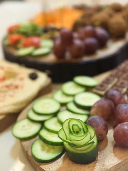 It's all in the details. Here, a cucumber is carved into a delicate rose, adding an artistic touch to a platter of fresh vegetables and dips. This is how I make every food display special.