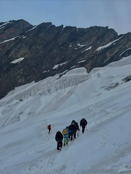A team making their way up a vast snowfield on Friendship Peak. The scale of the mountain is truly humbling.