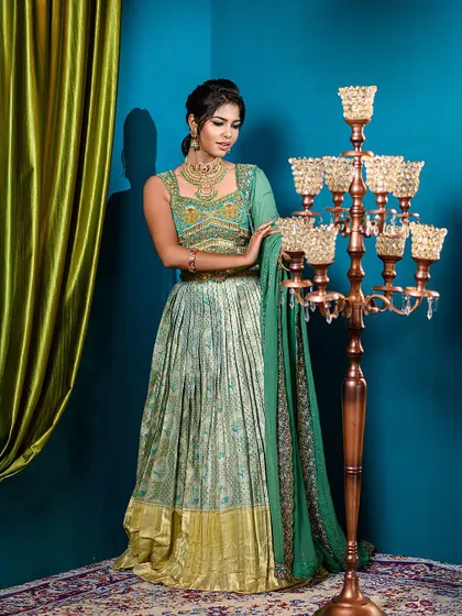 A full-length view of a stunning semi-traditional lehenga, set against a vibrant blue and green backdrop in my studio.