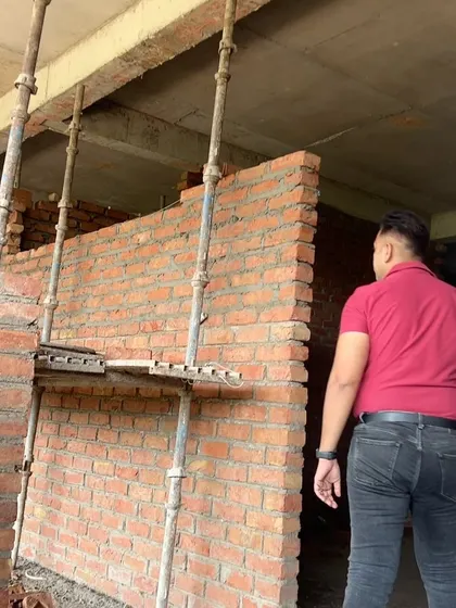On-site inspection of new wall construction. I personally verify the alignment and quality of the masonry work.