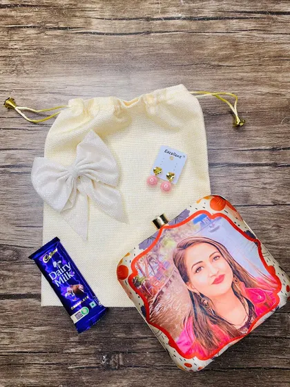Make it truly personal by adding her photo to the clutch. This Rakhi set for a sister features a custom photo-printed clutch along with other goodies.