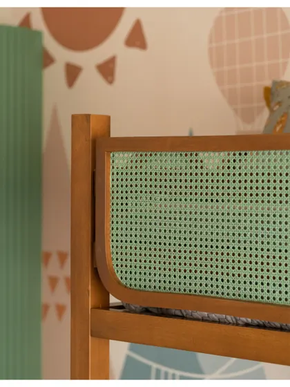 A close-up of the mint green rattan panel on the bunk bed, a detail that adds a pop of color and texture.