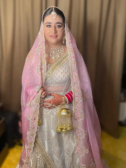 Another shot of the bride in her white and gold lehenga, showing the beautiful embroidery on her veil.