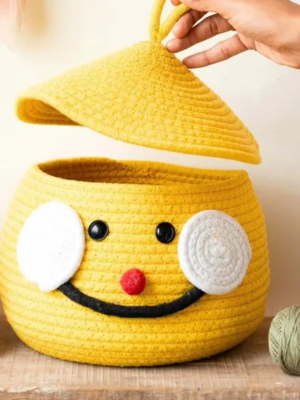 A professionally styled shot of our yellow smiley face rope basket. It's a cheerful and functional piece for any room in the house.