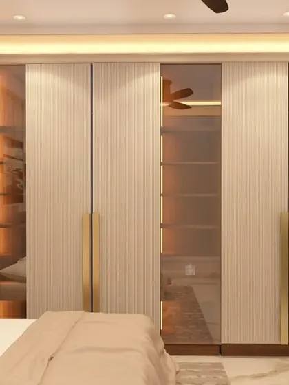 This master bedroom showcases a sophisticated wardrobe design with illuminated glass panels, offering a peek at the organized interior. The combination of fluted textures and metallic handles adds a touch of luxury and elegance.