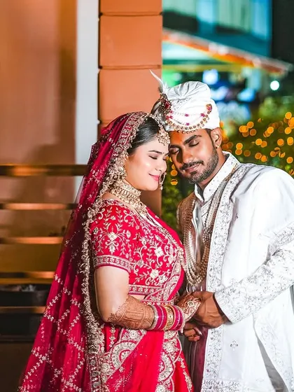 We believe the most beautiful moments are often the unposed ones. Here, the couple shares a quiet, tender moment together, framed by the warm glow of fairy lights. This is the natural, romantic style that defines our wedding photography.