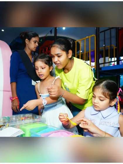 My staff is always on hand to guide and assist during creative activities. Here, children are getting help with a sand art project, ensuring everyone can participate and have fun.