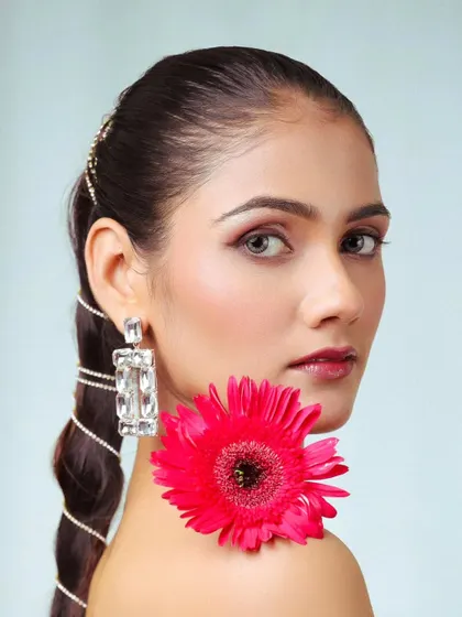 A creative beauty portrait using a flower as a prop. This adds an artistic and colorful element to a standard headshot.