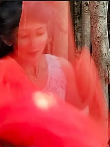 A blurry, motion-filled portrait playing with a red veil. This image captures the feeling of being swept away by emotion, inspired by a Khalil Gibran quote on life and love.