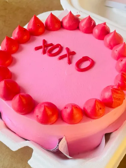 A Valentine's themed "XOXO" bento cake in a vibrant pink, perfectly sized for two to share.