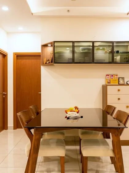 The Murlis' dining space combines a dark wood table with light-upholstered chairs, complemented by floating glass cabinets and herringbone wood paneling for a sophisticated, modern feel.