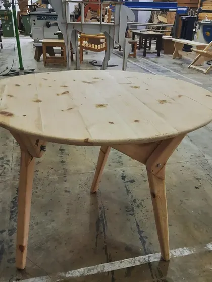 The same student-made table, now with its legs extended to function as a dining table, demonstrating clever design and skilled execution.