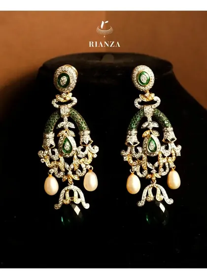 I design pieces that are both stunning and versatile. These elegant danglers, with their intricate diamond work, vibrant emeralds, and classic pearl drops, can be styled beautifully for a sangeet, cocktail party, or even after the wedding.