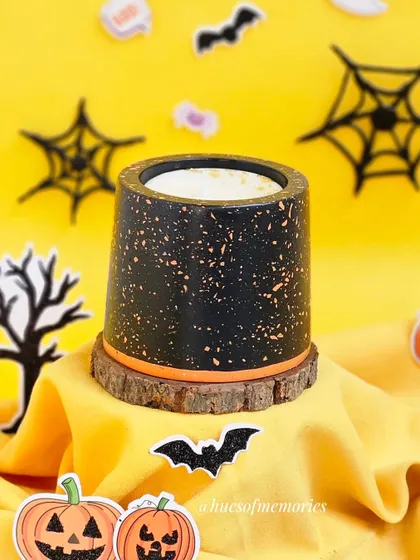 A single terrazzo candle, perfect for adding a touch of Halloween spirit to your decor. The black and orange design is both modern and festive.
