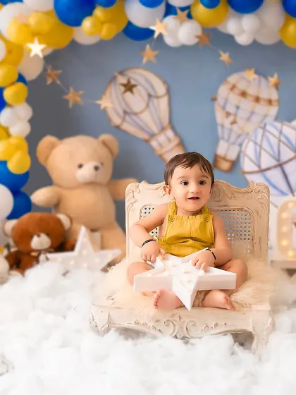 A sweet baby boy in a hot air balloon themed setup. The soft clouds and teddy bears create a dreamy and magical world for his milestone photos.