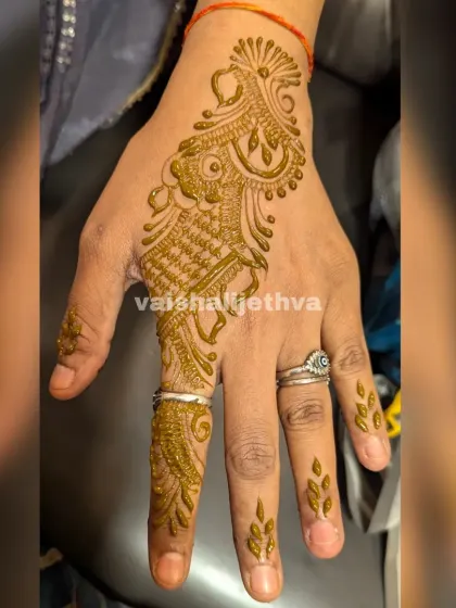 A simple Arabic design for a single finger and the side of the hand. This is a very minimalist and modern choice.