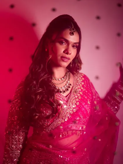 A confident and beautiful bridal portrait with dramatic lighting, showcasing the bride's modern style.