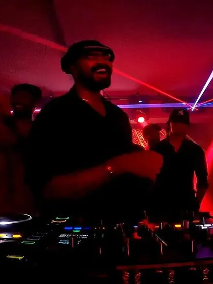 A shot of me smiling and enjoying the vibe during a collaborative DJ set. It's not just a performance; I'm having as much fun as the crowd.