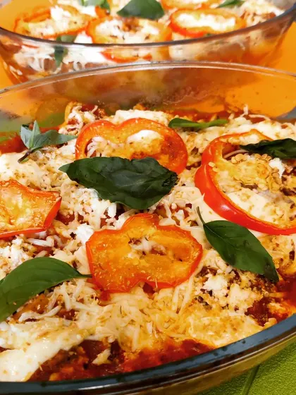Our homemade vegetarian lasagna, baked to perfection with layers of pasta, rich tomato sauce, vegetables, and melted cheese, garnished with fresh basil.