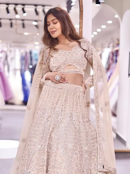 A closer look at the rose gold lehenga, showing the detail on the blouse and the beautiful drape of the dupatta. It’s a look of pure, understated luxury.