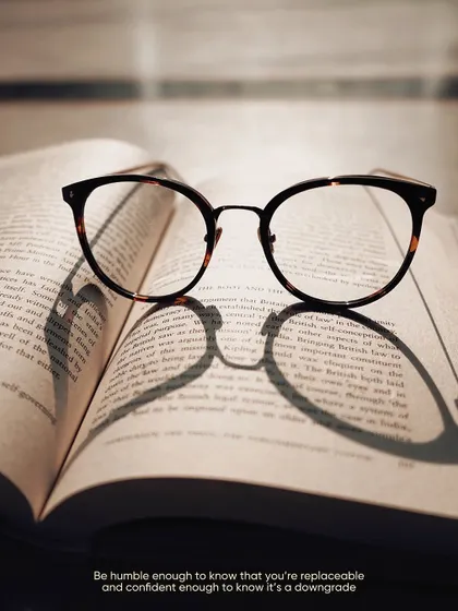 The shadow of a pair of glasses on an open book. This is a simple concept, but the strong shapes and lines create a compelling and graphic image.