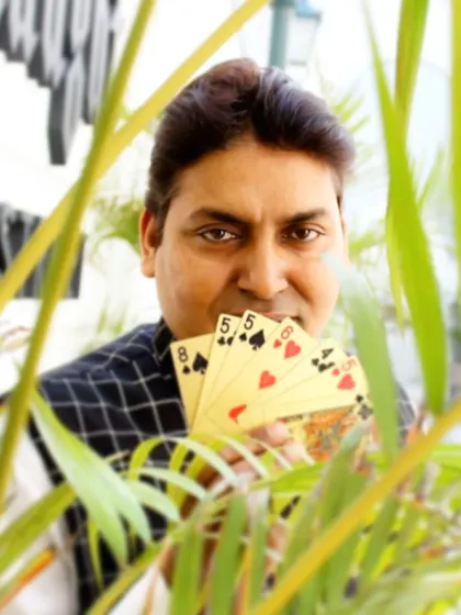 Holding a fan of cards, ready to amaze. Card magic is versatile and can be performed on a grand stage or at an intimate table setting, making it a staple of my shows.