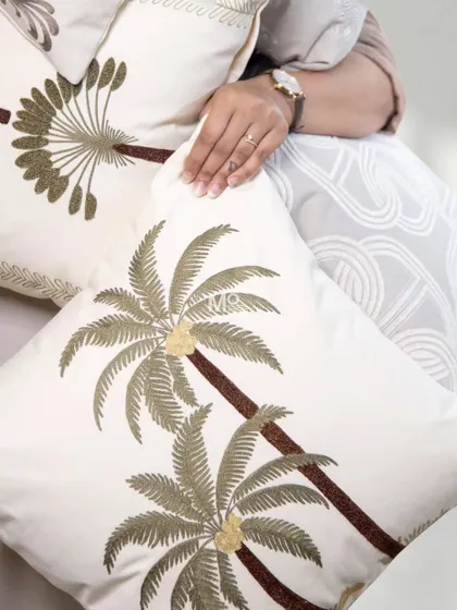 A close-up of our hand-finished embroidery, featuring a detailed palm tree motif. These designs, inspired by nature, art, and culture, bring a unique story to your decor.