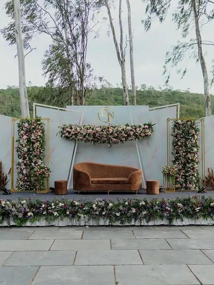 A wide shot of the chic, nature-inspired engagement stage set against a backdrop of tall trees, demonstrating how our designs can complement and enhance natural beauty.