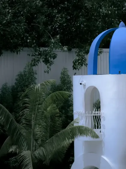 The iconic blue dome of a Santorini-themed building. The contrast between the vibrant blue and the white walls makes for a striking architectural detail.