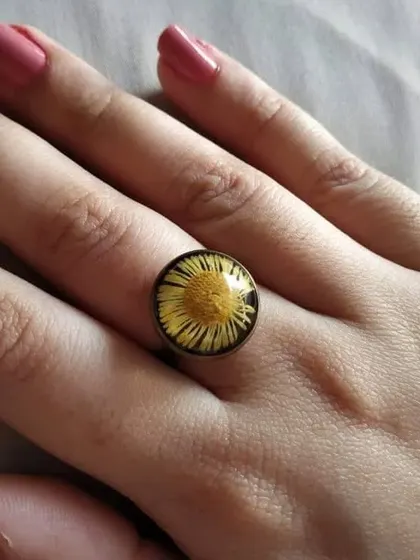 This ethnic ring features a preserved yellow flower, creating a bright and sunny look. The simple round setting is timeless and versatile.