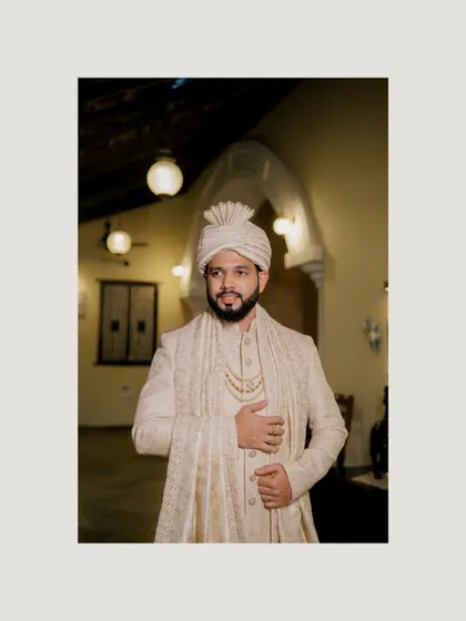 A classic portrait of the groom in his elegant sherwani, looking thoughtful and poised before the ceremony.