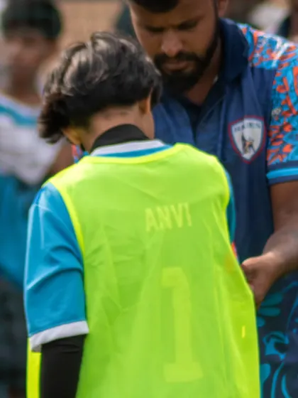 We build our players from the ground up. A coach offers guidance to a young player, reflecting our philosophy of nurturing homegrown talent.